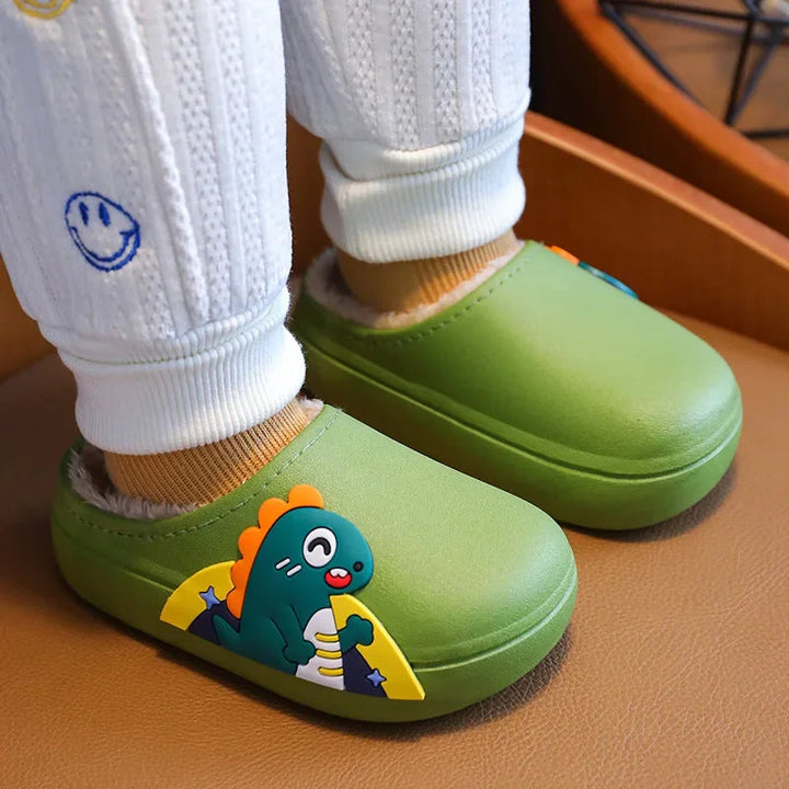 Green dinosaur slippers worn with white cuffed pants