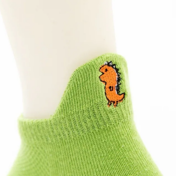 Raised heel tab on a green ankle sock with an orange dinosaur motif