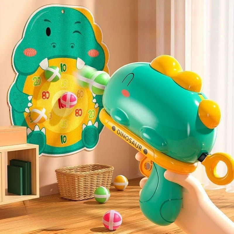 Hand holding a green dinosaur ball launcher aimed at a numbered dinosaur target