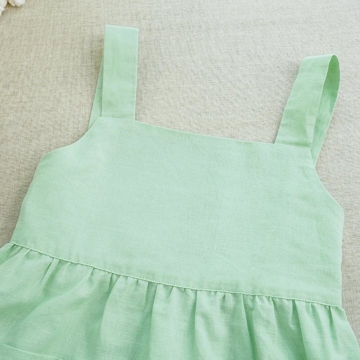 Green cotton dress laid flat, showing the square neckline and wide shoulder straps