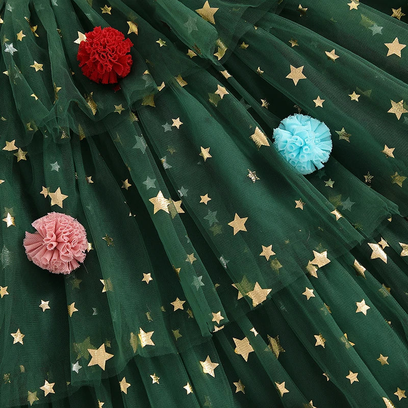 Green dress fabric with gold stars and red, pink, and blue pom-pom decorations