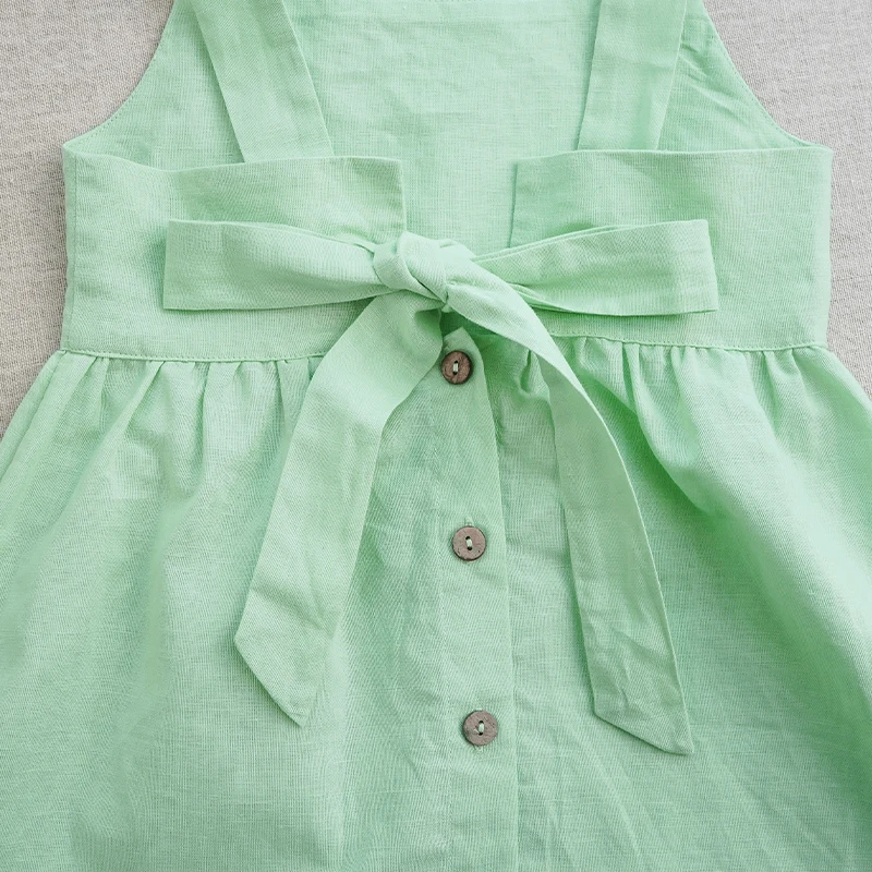 Back bow and decorative button row on the green cotton dress