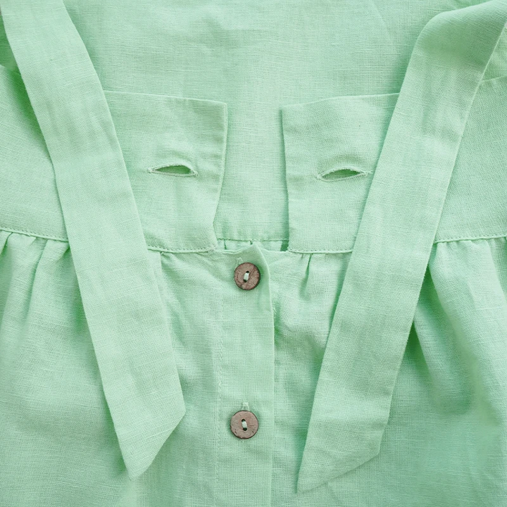 Untied strap ends and button details at the back of the green dress