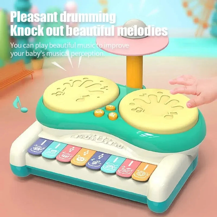 Green drum and keyboard toy with a hand reaching toward a yellow drum pad
