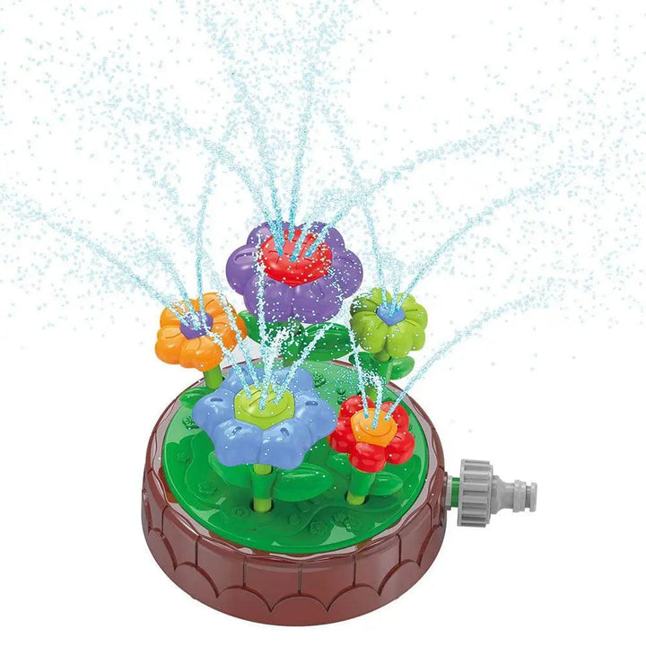 Flower sprinkler with a green platform, colorful flower heads and outward sprays of water