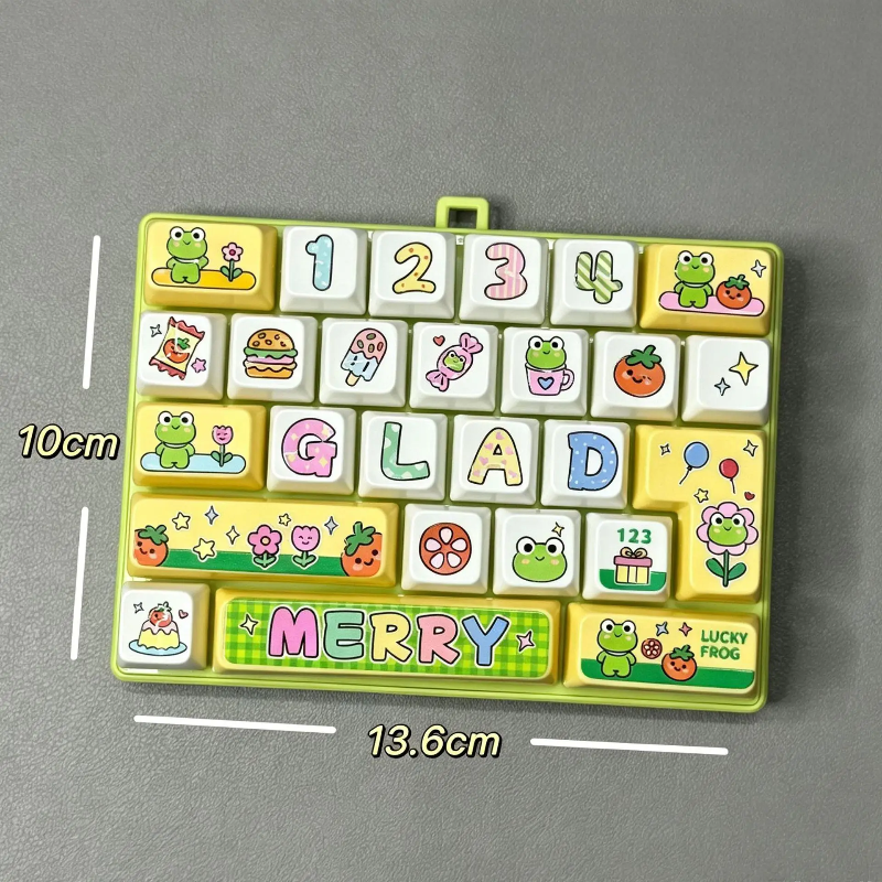 Green fidget keyboard with frog and letter designs, labeled 13.6 by 10 cm
