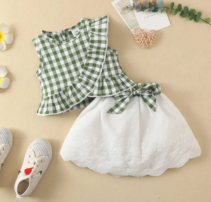 Green gingham ruffle top paired with a white skirt and coordinating bow