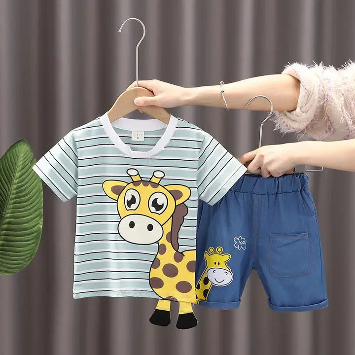 Green striped giraffe T-shirt held beside blue shorts with an elastic waistband