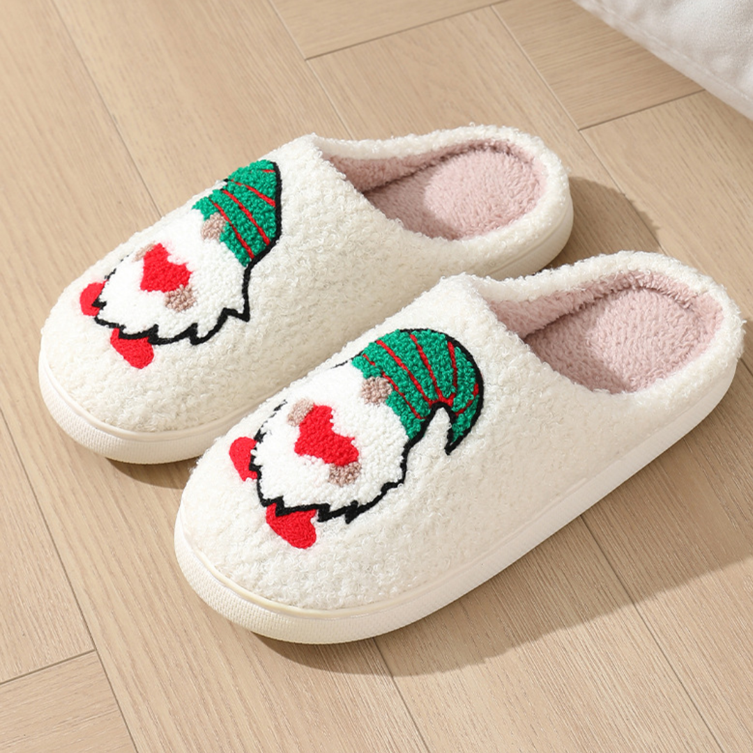 Open-back cream slippers featuring Santa faces with green patterned hats.