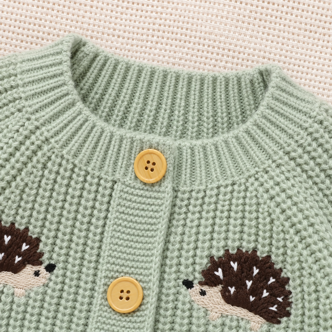 Close-up of the round ribbed neckline and front buttons on a green hedgehog jumpsuit.