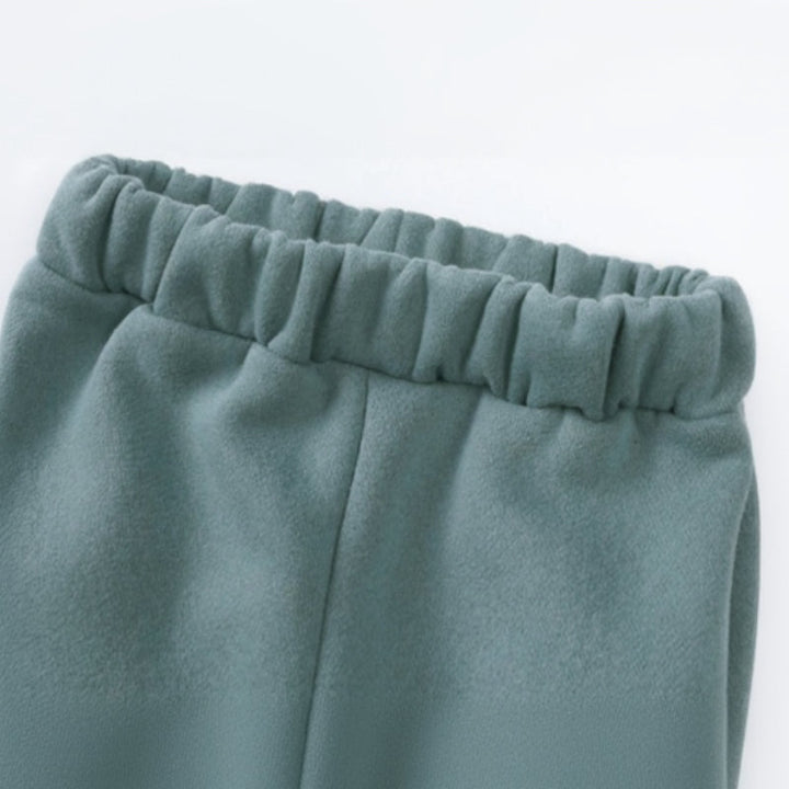 Close-up of the gathered elastic waistband on green jogger pants