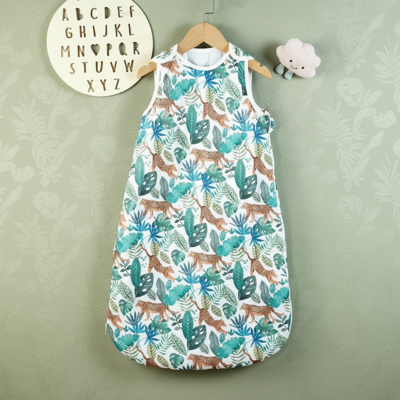 Jungle-print baby sleep sack with green leaves and spotted animals on a hanger