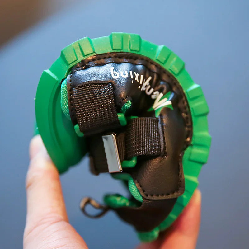 A green sandal bent by hand to show the flexible sole and black straps.