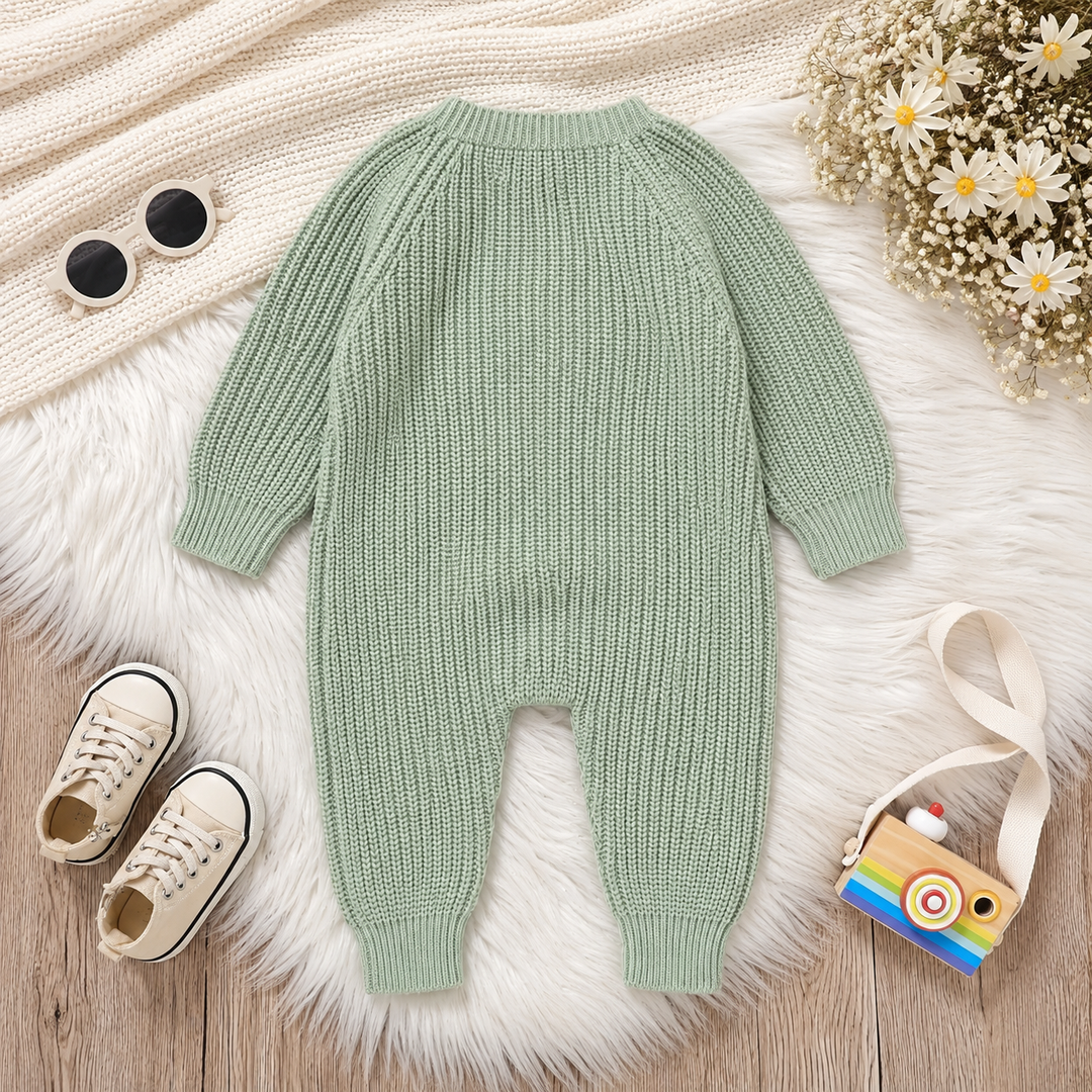 Back of a green knit baby jumpsuit with long sleeves and ribbed ankle cuffs.