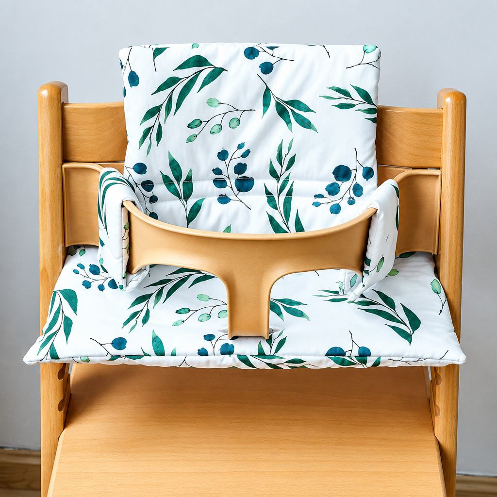 White high chair cushion with green and teal leaves on the seat and backrest
