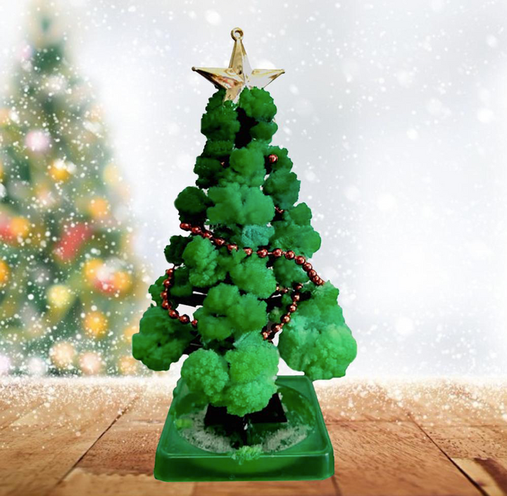 Miniature green Christmas tree with a gold star and red garland on a green base