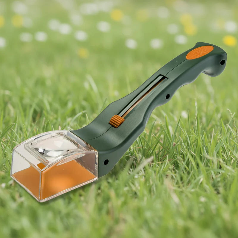 Green and orange bug catcher with a clear magnifying chamber resting on grass