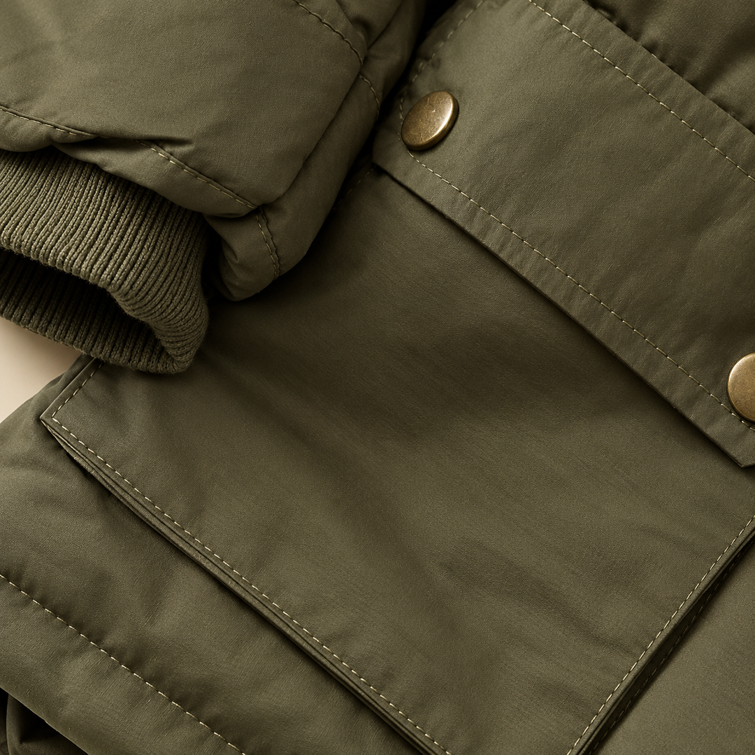 Green parka pocket flap, snap closures and ribbed sleeve cuff shown close up