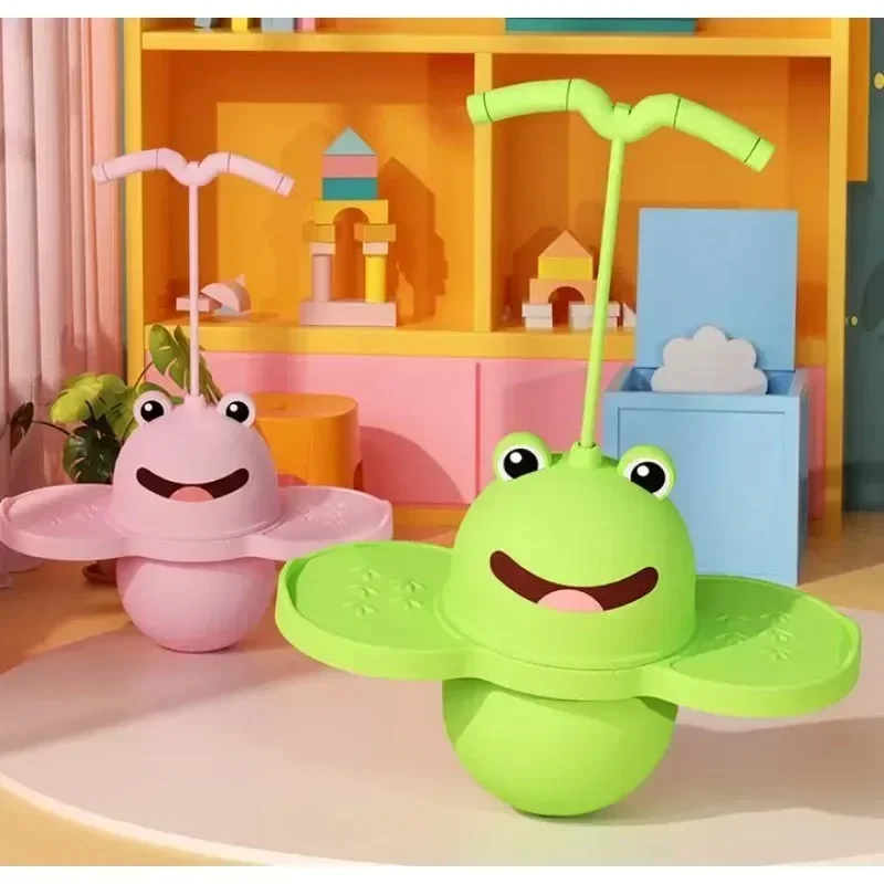 Green and pink frog pogo sticks with curved handles and foot platforms in a colorful playroom.
