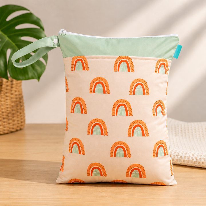 Green-trim diaper wet bag with orange rainbow prints