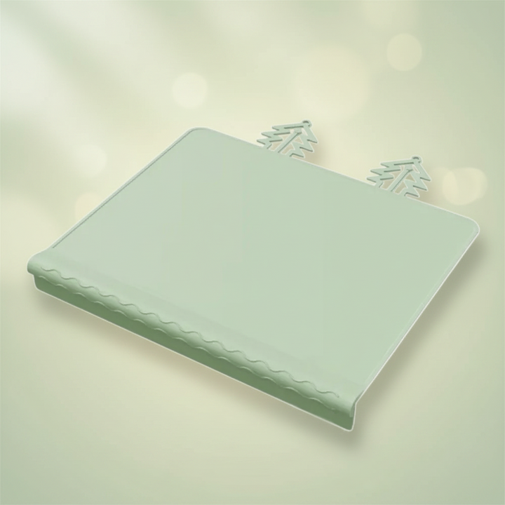 Green silicone placemat with raised edging and two tree-shaped tabs