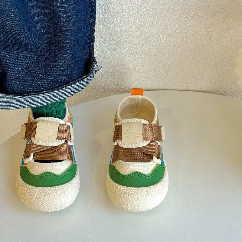 Green colorblock sandals viewed from the front, with one worn over a green sock