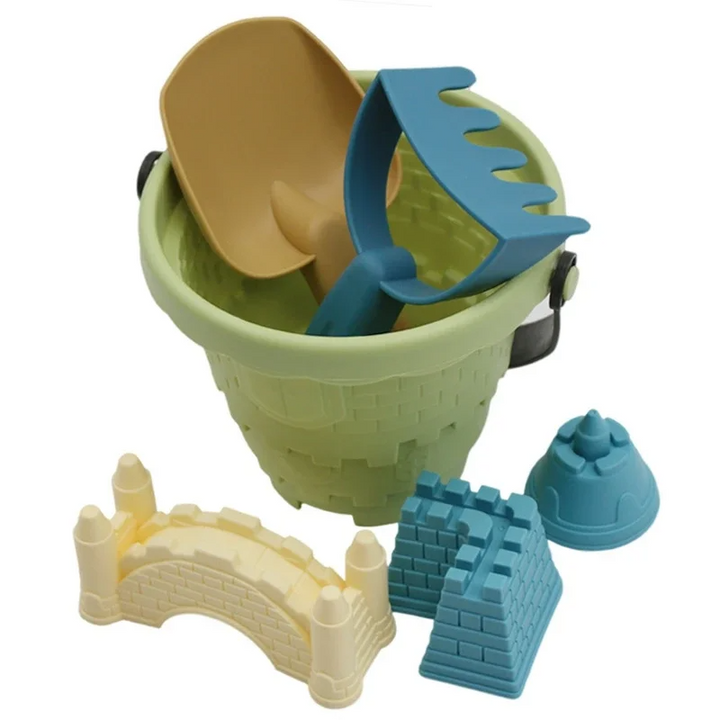Green sandcastle bucket with a yellow scoop, blue rake, and three sand molds