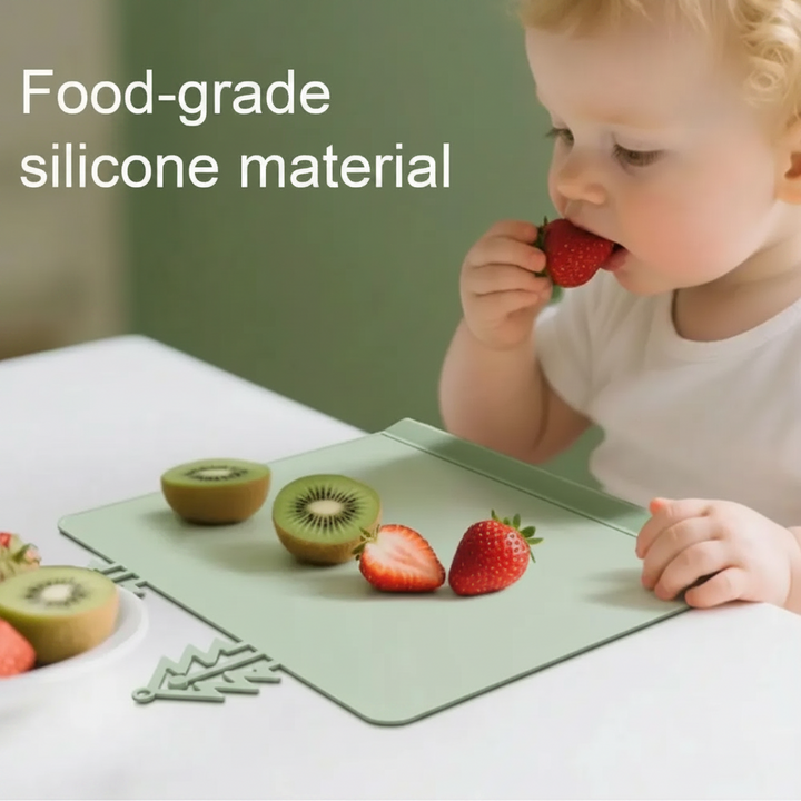 Child eating a strawberry at a green silicone placemat