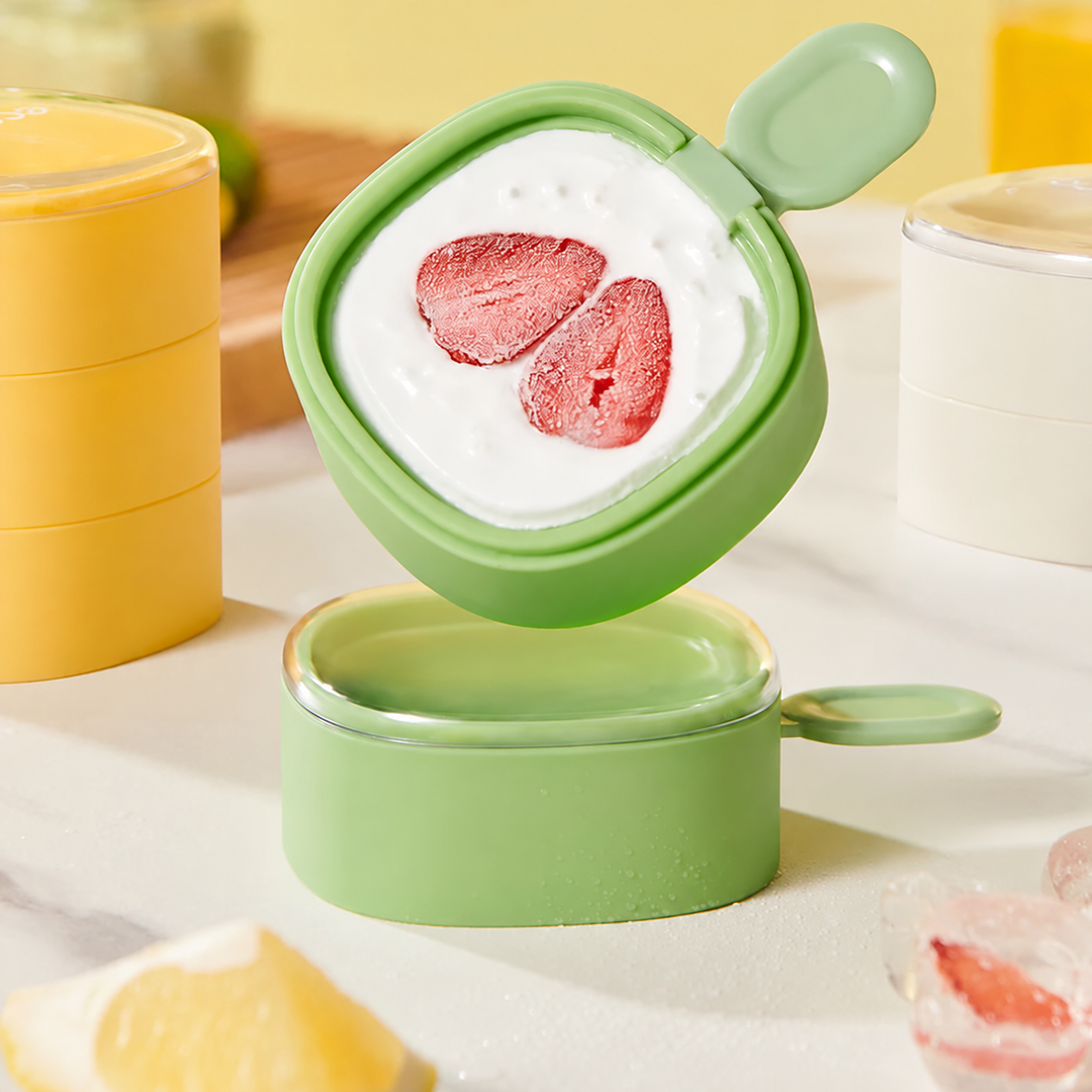 Green mold with a strawberry-topped frozen treat displayed above stacked molds.