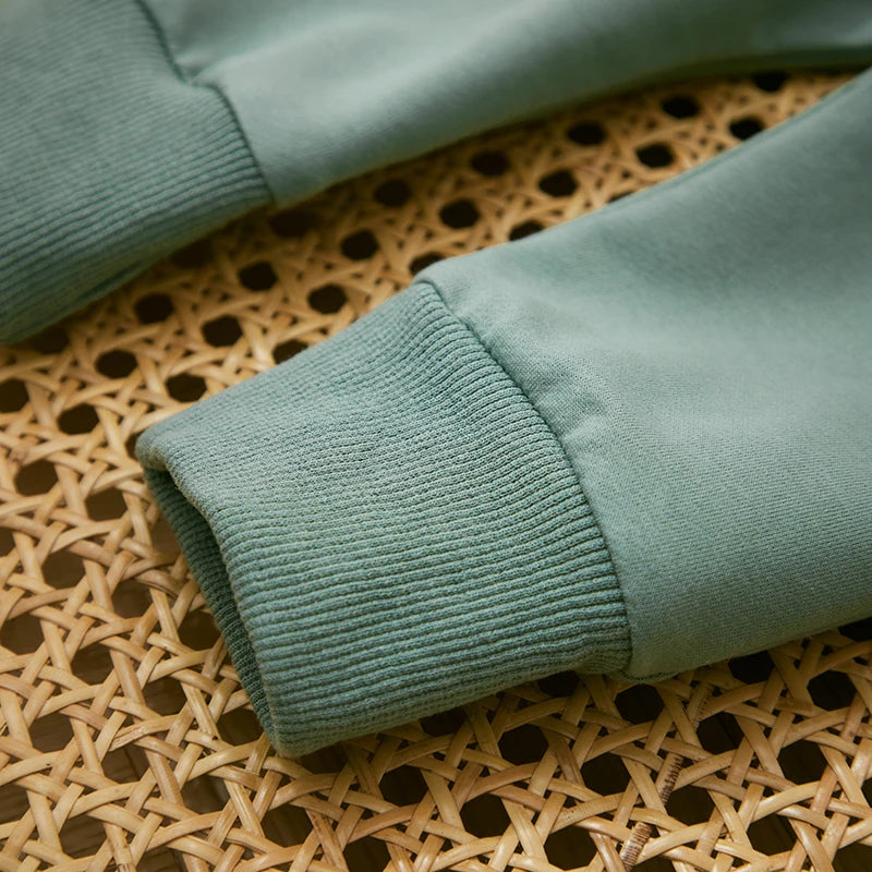 Close-up of ribbed green sweatshirt sleeve cuffs