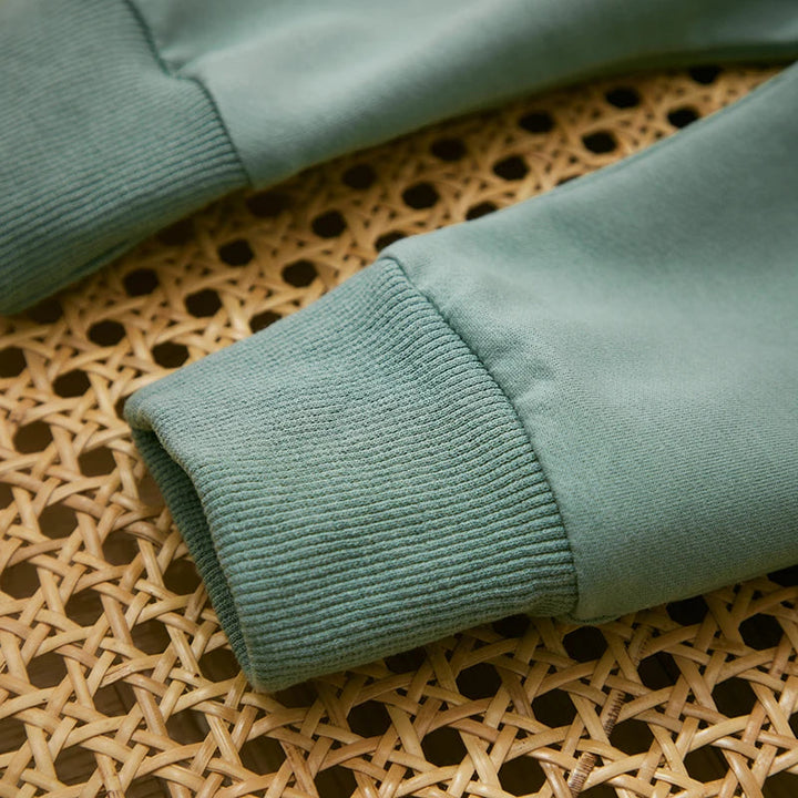 Close-up of ribbed green sweatshirt sleeve cuffs