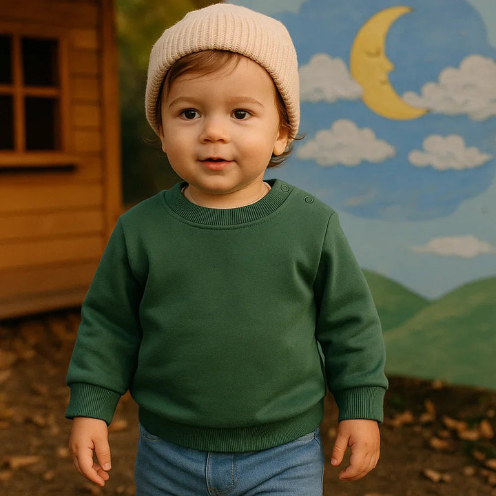 Child wearing a green crewneck sweatshirt and knit hat outdoors