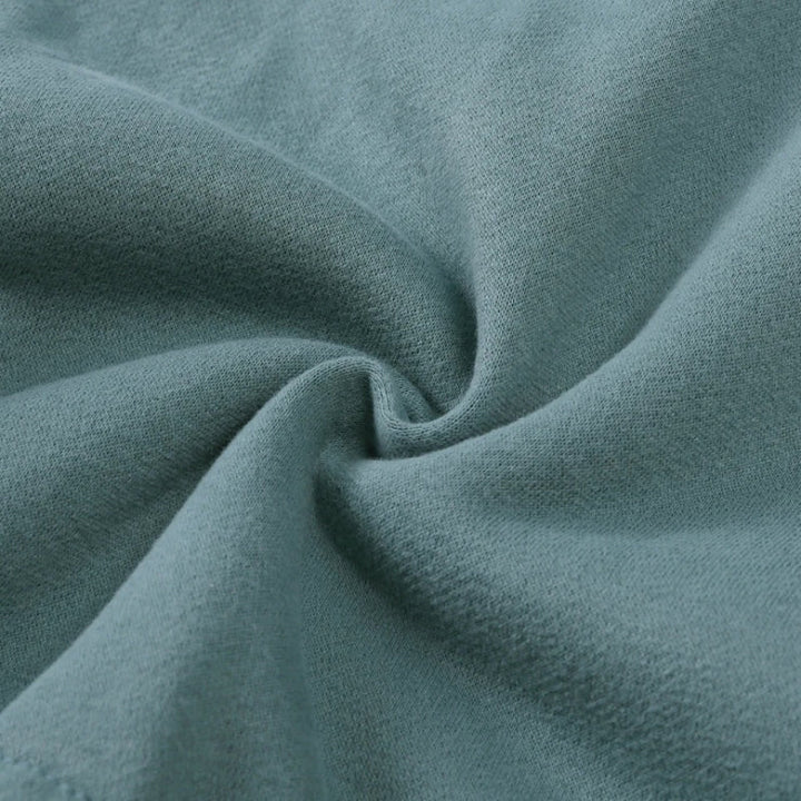 Green tracksuit fabric gathered to show its surface texture