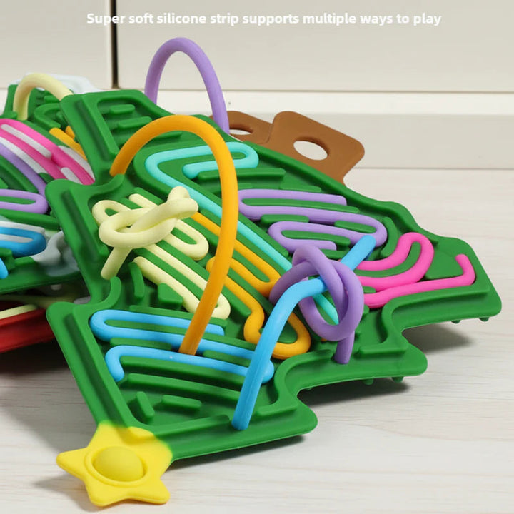 Close-up of flexible cords bending through the grooves of a green Christmas tree busy board.