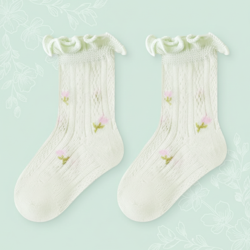Pair of pale green baby socks with floral details and ruffled cuffs.