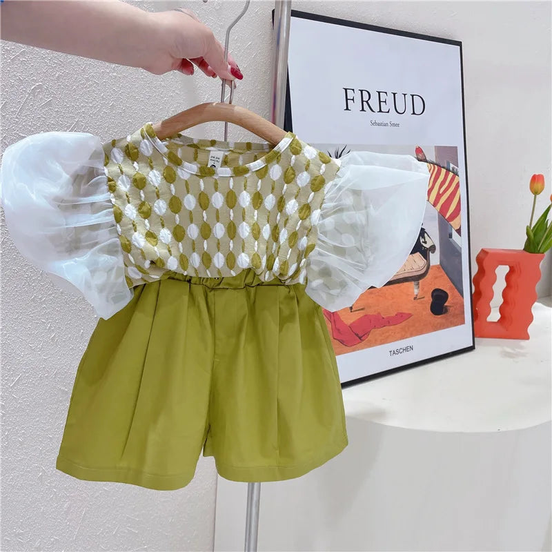 Green-and-white puff-sleeve top paired with green shorts on a hanger