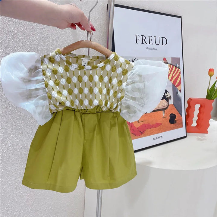 Green-and-white puff-sleeve top paired with green shorts on a hanger