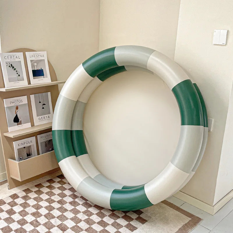 Green-and-white round inflatable pool with two stacked rings, displayed upright.