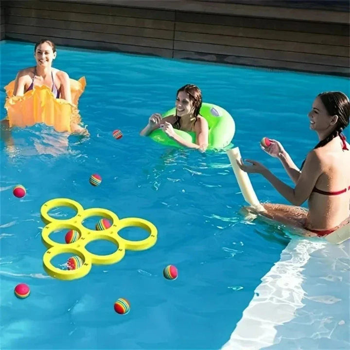 Group playing with a yellow floating ring target and colorful balls in a swimming pool