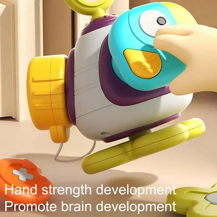 Hand grasping the turquoise bird-shaped panel on the activity toy