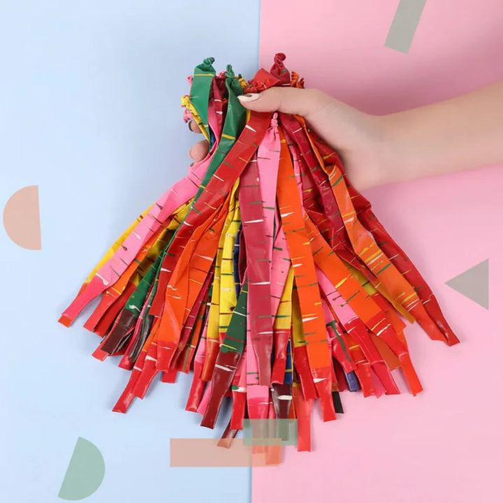 Hand holding a bundle of uninflated striped rocket balloons in assorted colors