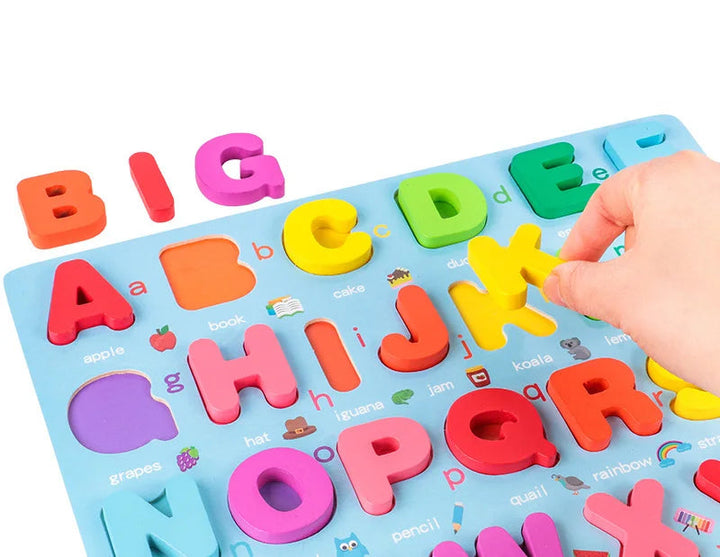 Hand lifting a yellow K piece from the uppercase wooden alphabet puzzle