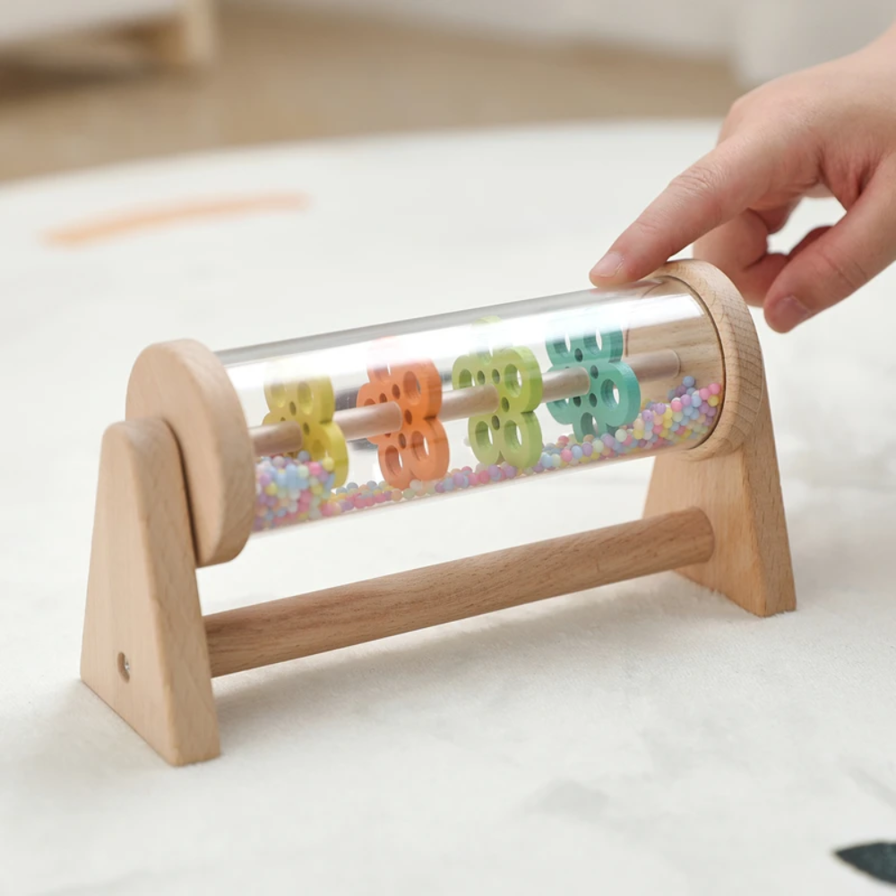 Hand on the end of the wooden rain toy&