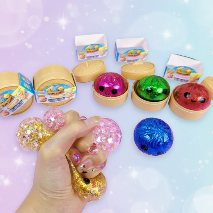 Hand squeezing pink and gold glitter toys beside colorful dumplings and open steamer-style cases