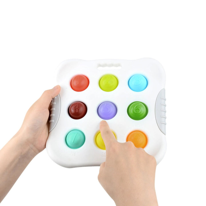 Hands holding a white sensory toy while a finger presses a yellow button