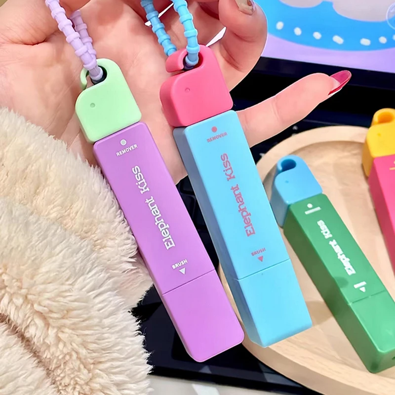 Colorful stain remover pens with loop straps held in a hand