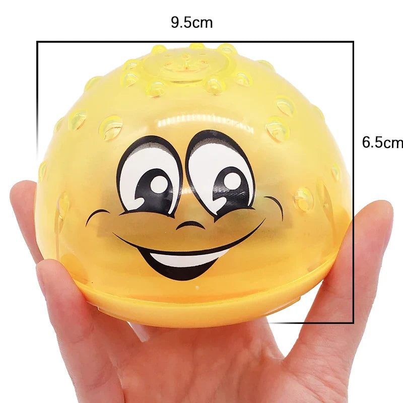 Yellow bath ball held in one hand, labeled 9.5 cm wide and 6.5 cm high