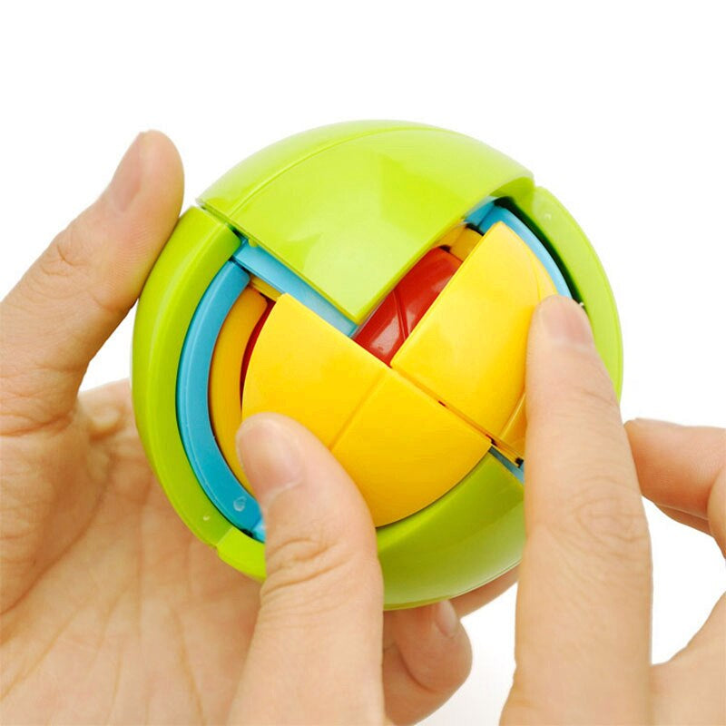 Hands fitting yellow sections into a green ball puzzle with blue and red inner layers