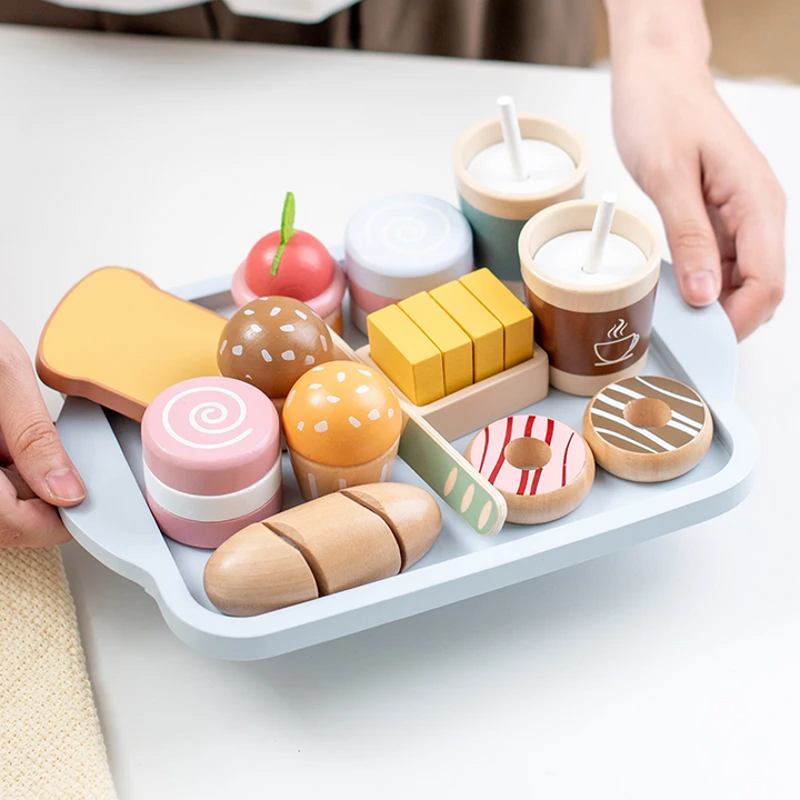 Hands carrying a blue tray filled with wooden breakfast food and pretend drink cups