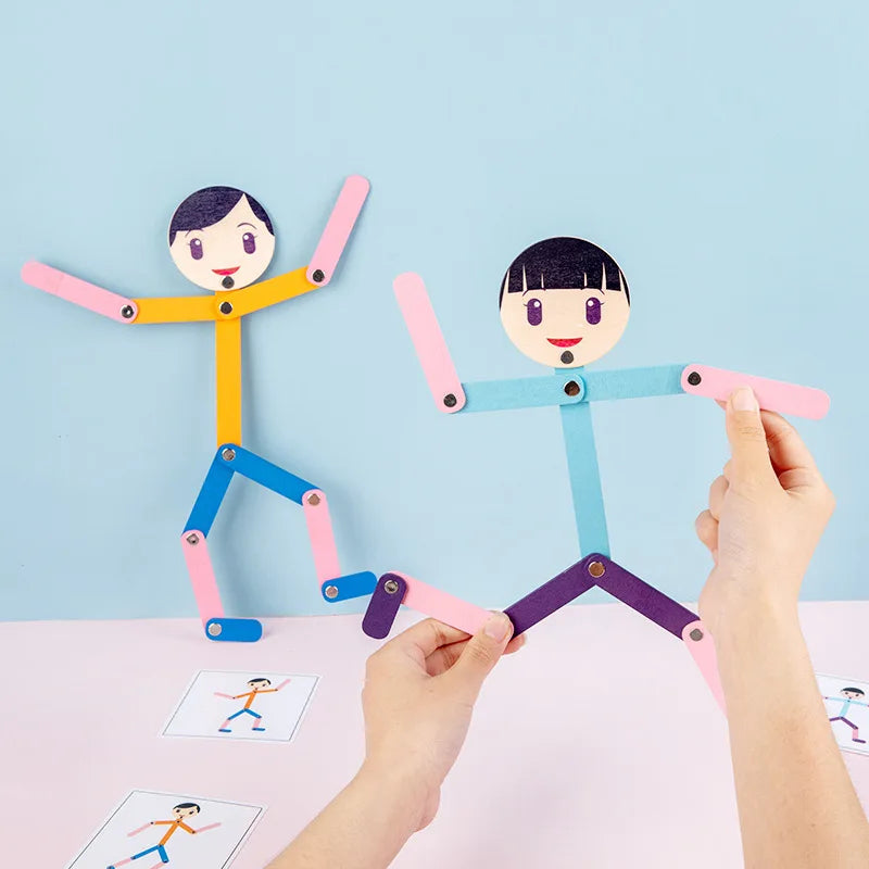 Hands repositioning a colorful jointed figure beside a second figure and pose cards